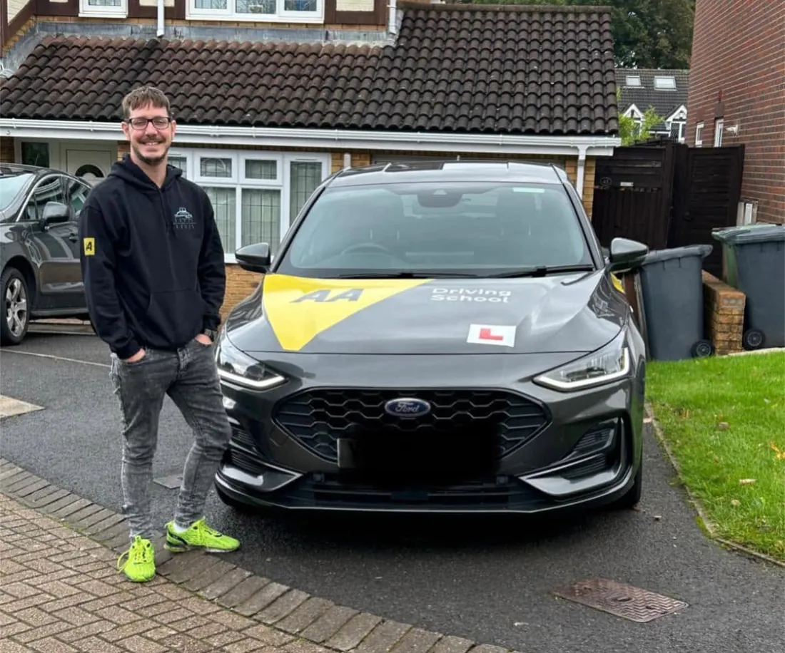 Ashley Foyle, driving instructor, standing beside his lesson car in Basingstoke